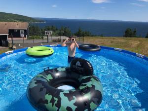 a man taking a picture in a swimming pool with two inflatables at The Iona Heights Inn in Iona