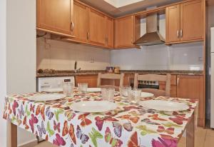 a kitchen with a table with a butterfly table cloth on it at Torredembarra in Torredembarra +8 photos