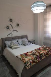 - une chambre avec un grand lit orné de fleurs sur le mur dans l'établissement Appartamento I Soffioni, à La Spezia