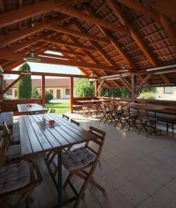 een grote patio met houten tafels en stoelen bij Hotel Kobero in Říčany u Brna