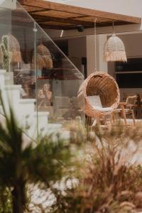 ヘルソニソスにあるGalazio Beach Resort by Estiaの籐椅子とテーブルが並ぶお部屋