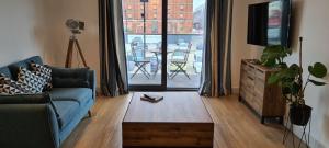 uma sala de estar com um sofá, uma televisão e uma mesa em Luxury 1 Bedroom Waterside Apartment in Gloucester Docks em Gloucester