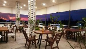 a restaurant with tables and chairs and a balcony at 449 Airport Phuket in Nai Yang Beach