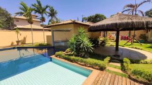 a villa with a swimming pool and a house at Relaxar em Búzios Praia de Manguinhos 5 suítes in Búzios