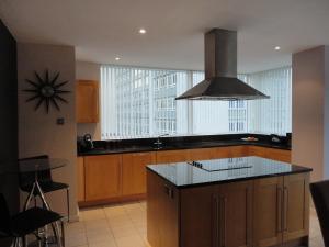 a kitchen with a island with a stove top oven at Luxury Apartment Best location in Liverpool city center in Liverpool +11 photos