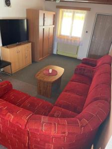 a living room with a red couch and a table at Apartmán Králiky in Králiky