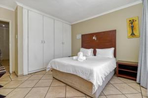 a bedroom with a bed with two towels on it at BM Gardens in Edenvale