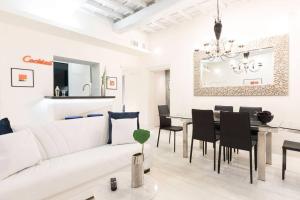 een woonkamer met een witte bank en een tafel bij Manara 57 Dream Apartment Trastevere in Rome