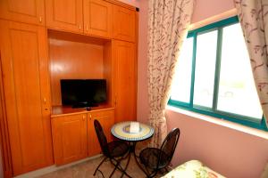 a small table and chairs in a room with a tv at Dubai Youth Hotel in Dubai