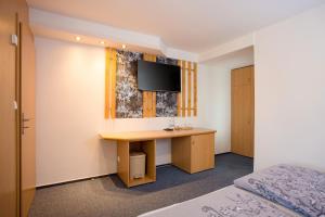 a hotel room with a desk and a tv at Hotel Kobero in Říčany u Brna