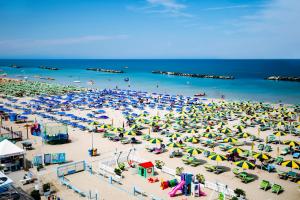 a beach filled with lots of colorful umbrellas at Residence Rainbow in Bellaria-Igea Marina
