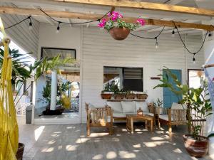 patio z kanapą, krzesłami i roślinami w obiekcie JAKES ON THE BEACH w mieście Las Peñitas