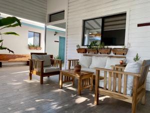 a porch with chairs and a couch and a window at JAKES ON THE BEACH in Las Peñitas