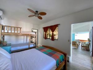 a bedroom with two bunk beds and a ceiling fan at JAKES ON THE BEACH in Las Peñitas