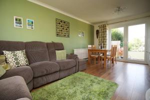 ein Wohnzimmer mit einem Sofa und einem Tisch in der Unterkunft 3 Bedroom family home Newport, Located next to M4 in Newport