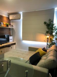 uma sala de estar com um sofá e uma televisão em APTO Vista INCRIVEL do VALE DOS VINHEDOS com AR e Garagem Coberta em Bento Gonçalves