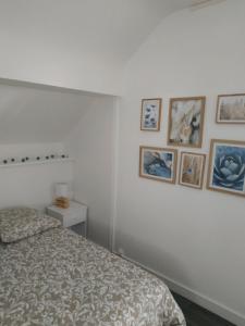 1 dormitorio con 1 cama y cuadros en la pared en Tosca - Appartement - Parking gratuit, en Orléans