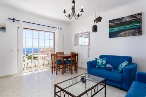 - un salon avec un canapé bleu et une table dans l'établissement Top Floor Ocean View Apartment – Near Beach Luz, à Luz