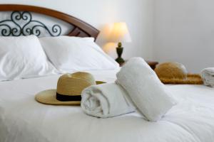 ルースにあるTop Floor Ocean View Apartment – Near Beach Luzのベッドの上に帽子とタオルを用意しています。