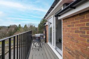 a patio with a table and chairs on a balcony at 2 Bedroom Penthouse with parking High Wycombe By 360Stays in High Wycombe