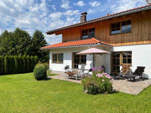 a house with a table and chairs and an umbrella at Haus Sieben Zwerge in Ehrwald