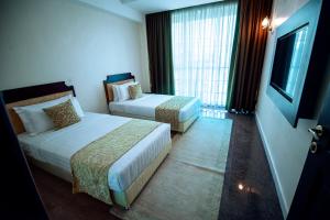 a hotel room with two beds and a window at Koki Hotel in Kampala