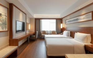 pokój hotelowy z 2 łóżkami i telewizorem w obiekcie Atour Hotel Wangfujing Ave Xinjiekou Nanjing w mieście Nankin