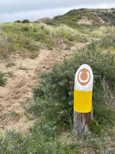 a yellow and white pole in the middle of a field at ZeeBedStay in Noordwijk aan Zee