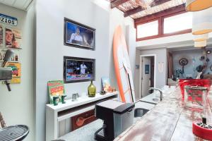 a living room with a table and a surfboard at Relaxar em Búzios Praia de Manguinhos 5 suítes in Búzios
