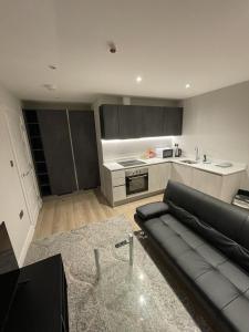 a living room with a couch and a kitchen at Whole apartment in Harrow Town centre in Harrow