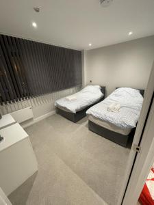 a bedroom with two beds and a window at Whole apartment in Harrow Town centre in Harrow