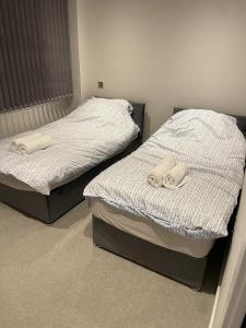 two beds sitting next to each other in a bedroom at Whole apartment in Harrow Town centre in Harrow