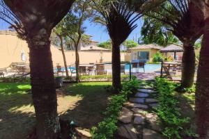 a view of a yard with trees and a swimming pool at Relaxar em Búzios Praia de Manguinhos 5 suítes in Búzios