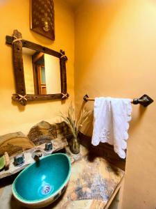 a bathroom with a blue sink and a mirror at Finca La Candelaria in Maimará