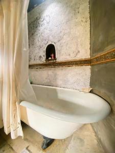 a bath tub in a bathroom with a hole in the wall at Finca La Candelaria in Maimará