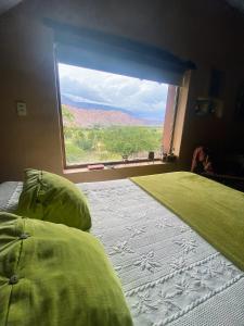 a bedroom with a bed and a large window at Finca La Candelaria in Maimará