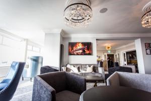 a living room with couches and a chandelier at Doric Hotel in Blackpool