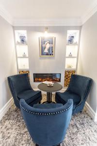 a living room with chairs and a table and a fireplace at Doric Hotel in Blackpool