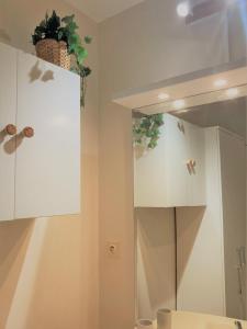 La salle de bains est pourvue de placards blancs et d'un miroir. dans l'établissement Studio proche plage balcon et parking, à Deauville
