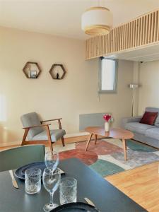 a living room with a table and a couch at Studio proche plage balcon et parking in Deauville