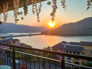 a view of a lake at sunset from a balcony at Portofino in Lavasa