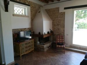 a living room with a tv and a fireplace at Villa Casale Settesoldi in Salemi
