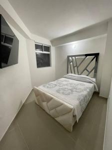 1 dormitorio con 1 cama en una habitación blanca en Aparta-hotel Laureles 203, en Medellín
