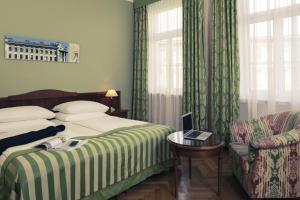 a bed room with two beds and a desk at Hotel Secession an der Oper in Vienna