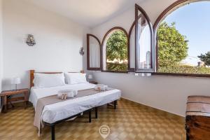 um quarto com uma cama e duas janelas em Palm Villa Costa Rei - 50m from the Sea em Monte Nai