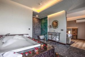 baño grande con bañera y lavamanos en NEHİR OTEL en Pelitli