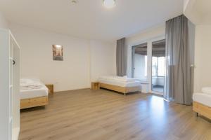 1 dormitorio con 2 camas y suelo de madera en T&K Apartments-Duisburg 4 Zimmer Apartment, en Duisburg