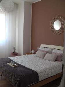 - une chambre avec un grand lit et un miroir mural dans l'établissement Appartamento ARCOBALENO, à Tirano