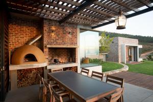 um pátio com uma mesa e um forno de pizza em Taaibosch Collection em Stellenbosch