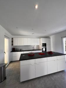 a kitchen with white cabinets and a black counter top at Casa Sognu di Orizonte in Figari